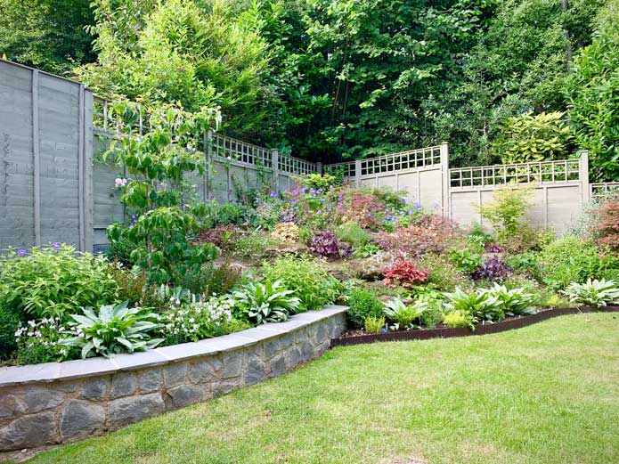 A low garden wall surrounded by planted flowers